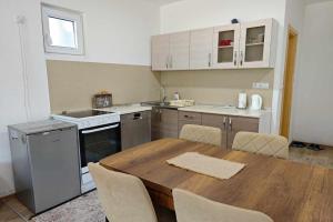 a kitchen with a wooden table with chairs around it at Villa Pliva Lake 2 in Jajce +11 photos