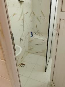 a white bathroom with a shower and a sink at Alkan mozayik otel in Urfa