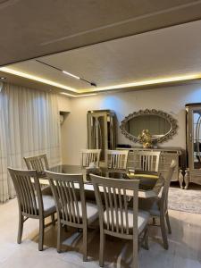 une salle à manger avec une table, des chaises et un miroir dans l'établissement Z m abartment hotel, à Giza