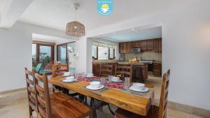 a dining room and kitchen with a wooden table and chairs at Casa Bahía Linda by Kivoya in Puerto Vallarta