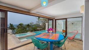 a dining room with a table and chairs and a pool at Casa Bahía Linda by Kivoya in Puerto Vallarta