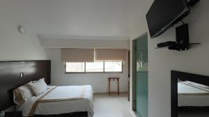 a bedroom with a bed and a fireplace and a television at Hotel Boutique Yaocalli in San Martín de las Pirámides