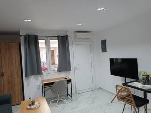 a living room with a desk and a television at Heraklion Central Studio MaZa1 in Néa Alikarnassós