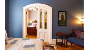 una camera da letto con pareti blu e un letto e una sedia di Wyatt Earp - Historic Hotel a Cimarron