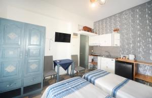 a small bedroom with two beds and a kitchen at Panorama Studios & Apartments in Myrties