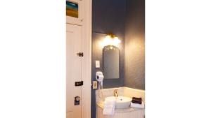 un bagno con lavandino e specchio di Wyatt Earp - Historic Hotel a Cimarron