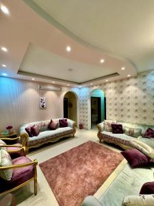 een grote woonkamer met banken en een tapijt bij نورة ريزيدينس in Taif