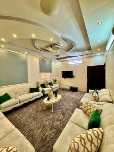 een grote woonkamer met banken en een flatscreen-tv bij نورة ريزيدينس in Taif