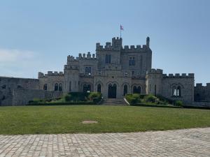 a castle with a grass field in front of it at La Forestière du Château in Condette