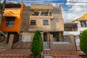 an old house with a fence in front of it at Hotel Colores Boutique in Medellín
