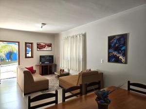 a living room with a couch and a table at Temporada Belas Casas in São Pedro