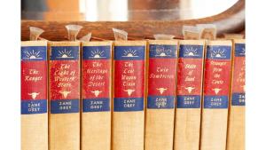 een rij boeken op een plank bij Zane Grey - Historic Hotel in Cimarron