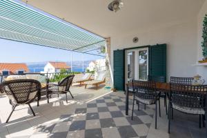 a patio with a table and chairs and a view at Apartment Pepica in Postira