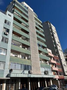 two tall buildings with cars parked in front of them at Flat Embarcadero com camareira in Porto Alegre