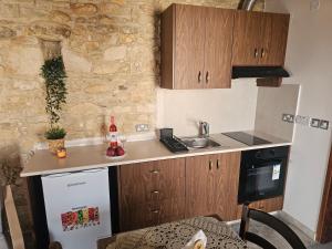 a small kitchen with a sink and a refrigerator at Katerinas sweet place studio 2 in Tsadha