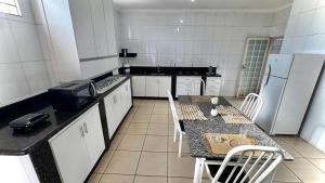 a kitchen with a table and chairs and a refrigerator at Casas de Temporadas - Hotel Recanto do Sossego in Uberlândia +29 photos