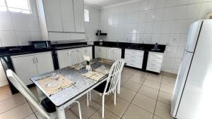 a kitchen with a table and chairs and a refrigerator at Casas de Temporadas - Hotel Recanto do Sossego in Uberlândia