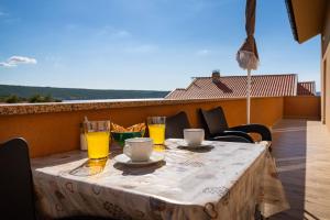 a table with two glasses of orange juice on a balcony at Luxury Apartment Luce in Novigrad Dalmatia