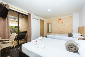 a hotel room with two beds and a table and a chair at Hotel Colores Boutique in Medellín