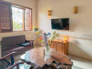 a living room with a table with a vase of flowers on it at Cempaka Villa in Pesanggaran