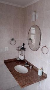a bathroom with a sink and a mirror at Apto confortável cozinha, smart tv in Joinville +27 photos