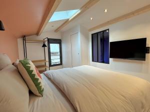 Un dormitorio con una cama grande y un televisor de pantalla plana. en Sur les traces de Cyrano Duplex, en Bergerac 3 fotos más