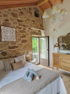 een slaapkamer met een bed en een stenen muur bij A Solaina da Bouza in Cambados