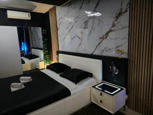 a bedroom with a large bed with a marble wall at Glamour Wellness Apartments in Zagreb +32 photos
