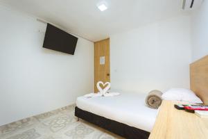 a hotel room with a bed and a tv at Hotel Colores Boutique in Medellín