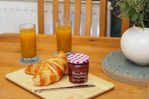 a table with a plate of croissants and orange juice at Spacious Comfy 4 Bed Home - Sleeps up to 7 & Pets in Derby