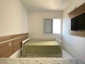 a small room with a bed and a tv at Apto Alto Padrão Frente Mar no melhor condomínio in Samaritá