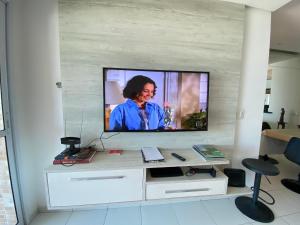 a television on a wall in a living room at Apto Alto Padrão Frente Mar no melhor condomínio in Samaritá