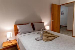 a stuffed animal is laying on a bed at Apartamento 400m de Playa Chiquita, ideal para tele trabajo in Talamanca