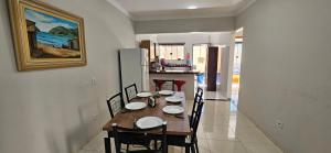 a dining room with a table and chairs and a kitchen at Casa confortável, com 3 quartos, bem localizada! in Maringá