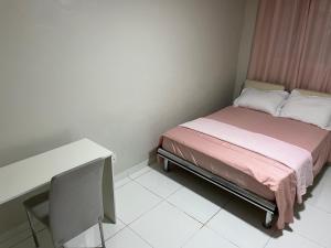a small bedroom with a bed and a desk at Apto Elegante no Vieiralves in Manaus