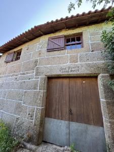 ein Backsteingebäude mit einer hölzernen Garagentür in der Unterkunft Casa do Arte - Peaceful Retreat with a Pool near Guimarães in São Torcato + 40 Fotos