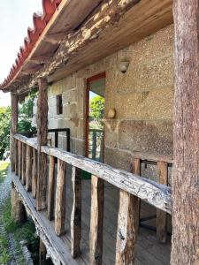 eine Holzveranda eines Blockhauses mit einem Fenster in der Unterkunft Casa do Arte - Peaceful Retreat with a Pool near Guimarães in São Torcato