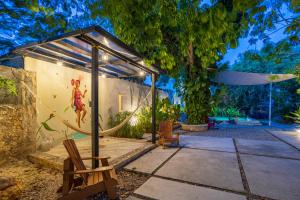 a tent with a hammock in a garden at night at Exclusivo Oasis con Alberca en el Centro Histórico in Mérida