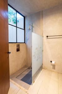 a bathroom with a shower with a glass door at Exclusivo Oasis con Alberca en el Centro Histórico in Mérida +19 photos