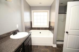 a bathroom with a sink and a bath tub at The Pit Stop Clarksville Rest Easy in Clarksville +30 photos