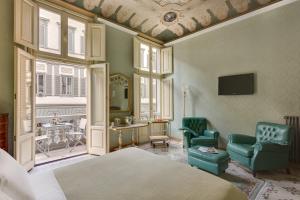 Un dormitorio con una cama y dos sillas y una mesa. en B&B Cavour10 Firenze, en Florencia