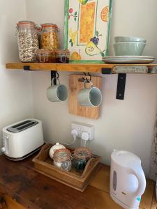 a kitchen with a shelf on the wall with jars at Mole End Bed and Breakfast in Llangwm +6 photos