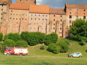 a fire truck parked in front of a castle at Apartament A1, City of Grudziadz 42m Wi Fi in Grudziądz