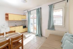 a kitchen with a table and a dining room at SIDI apartments in Polychrono