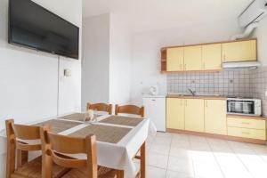 a kitchen and dining room with a table and chairs at SIDI apartments in Polychrono