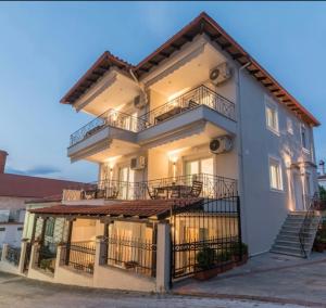 a large white building with balconies and stairs at SIDI apartments in Polychrono