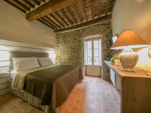 um quarto com uma cama e uma mesa com um candeeiro em Casa Zeni em Cortona