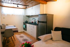 a small kitchen with a stainless steel refrigerator and a couch at Apartment Antigona in Gjirokastër