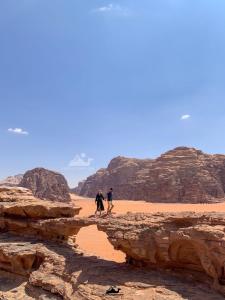 two people walking through the desert at Wadi Rum ZAAD luxury Camp in Wadi Rum +55 photos