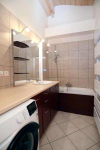 a washing machine in a bathroom with a sink and a tub at Superbe Appartement Deux Alpes Cosy et chaleureux 6 personnes in Les Deux Alpes